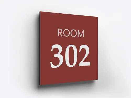 A red aluminum address sign showing a room number in white.