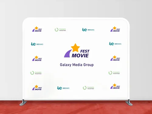 A tension fabric backdrop showcasing a white display placed on a red carpet for a movie festival.