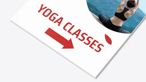 Simple foam board sign with a clean white background, bold red text and arrow pointing to yoga classes, featuring a photo of a woman meditating outdoors