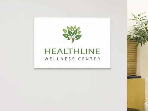 Wooden logo sign for Healthline Wellness Center with green branding.