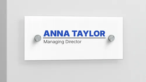 Plastic name label sign on the wall displaying Anna Taylor, Managing Director.