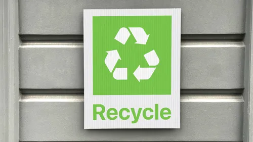 Green plastic recycling sign with a recycling image and the word Recycle.
