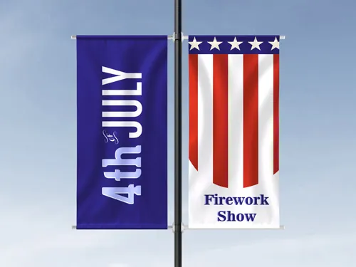 ​A single vertical pole banner featuring an American flag design, mounted on a street pole in an urban environment