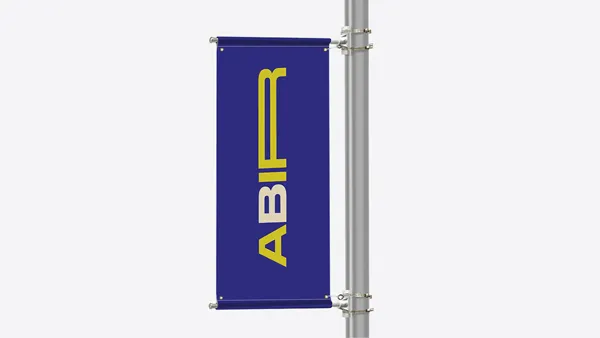 A single vertical pole banner with bold, colorful graphics mounted on a street pole in an urban setting