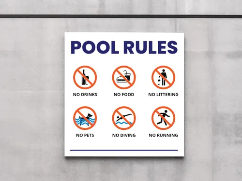 A white aluminum property sign displaying a set of public pool rules.
