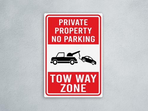 A sign with Private Property No Parking Tow Away Zone in bold letters, warning drivers.