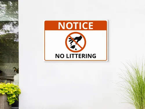 Notice No Littering wooden sign with a forbidding hand symbol, urging clean yards.