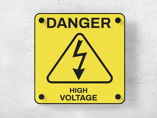 Aluminum safety sign in yellow and black warning of high voltage.