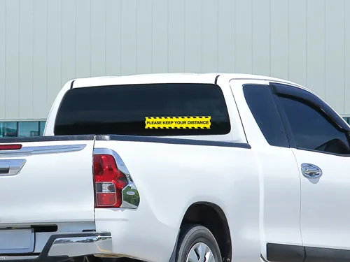 A safety opaque truck window decal in yellow on the rear windshield of a truck.