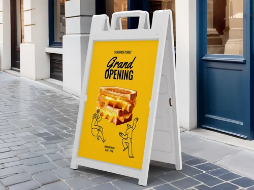 Yellow sandwich board with “Grand Opening,” two men’s silhouettes, and a sandwich image.