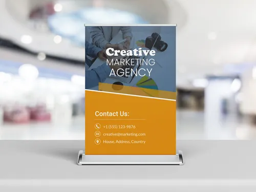 Tabletop retractable banner for a creative marketing agency with contact details displayed.