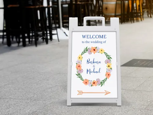 Wedding sandwich board with bride and groom's names and a welcoming message.